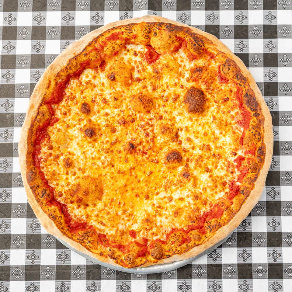 Large cheese pizza with tomato sauce and a golden-brown crust on a black-and-white checkered tablecloth.