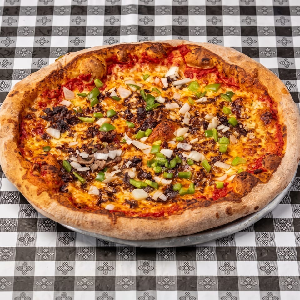 Large wood-fired pizza topped with melted cheese, mushrooms, onions, green peppers, and crumbled meat on a metal tray.